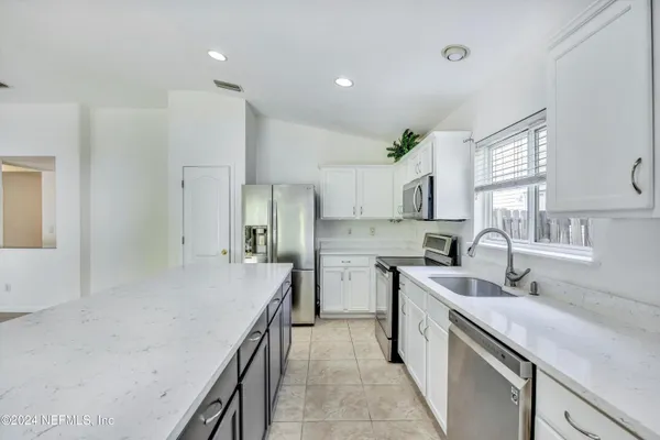 a kitchen with a sink stove and cabinets