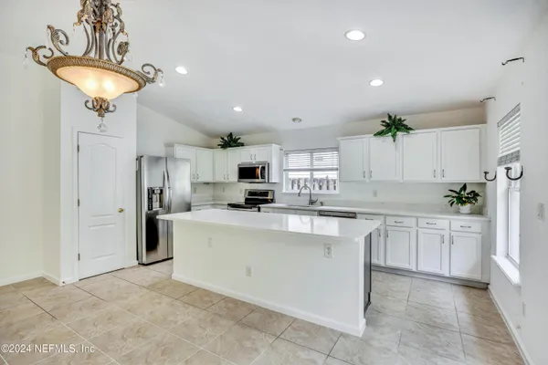 a kitchen with stainless steel appliances a refrigerator sink and stove