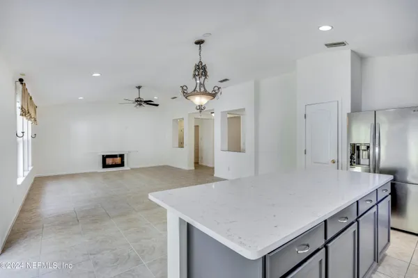 a view of a kitchen with a center island and a refrigerator