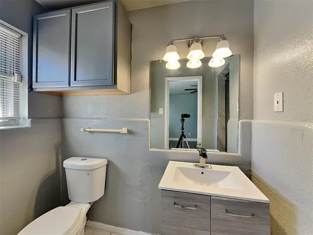 a bathroom with a toilet sink and mirror