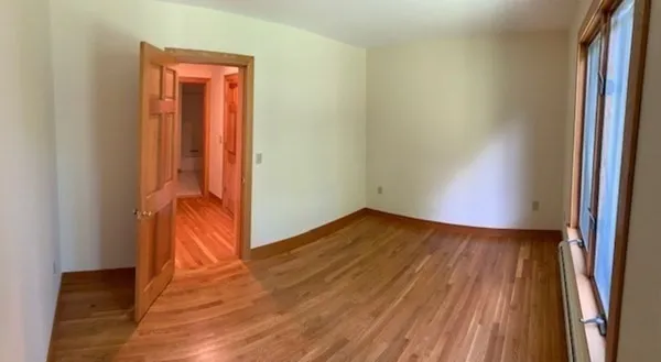 an empty room with wooden floor and closet