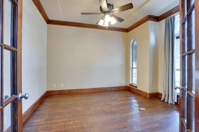 a view of empty room with window and ceiling fan