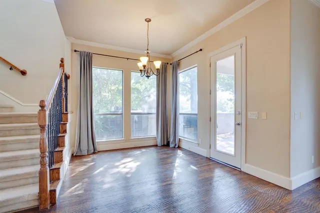 a kitchen with stainless steel appliances granite countertop a stove a sink dishwasher a refrigerator and white cabinets with wooden floor