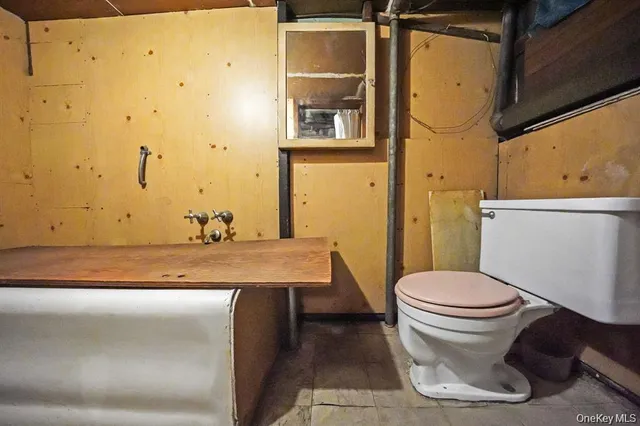 a bathroom with a granite countertop toilet and a sink