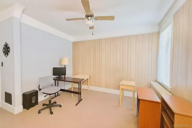 a view of a workspace with furniture and a window