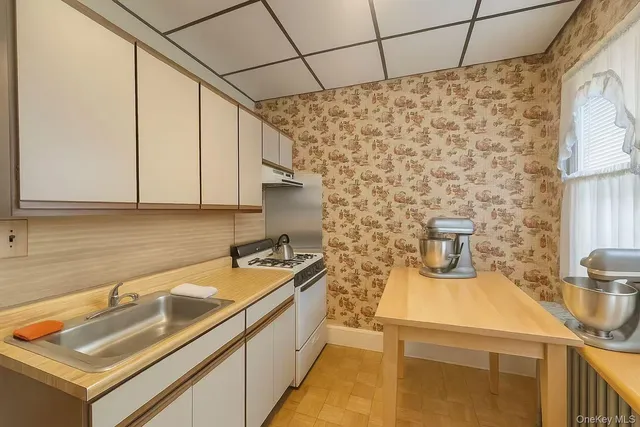 a kitchen with sink a stove and a window
