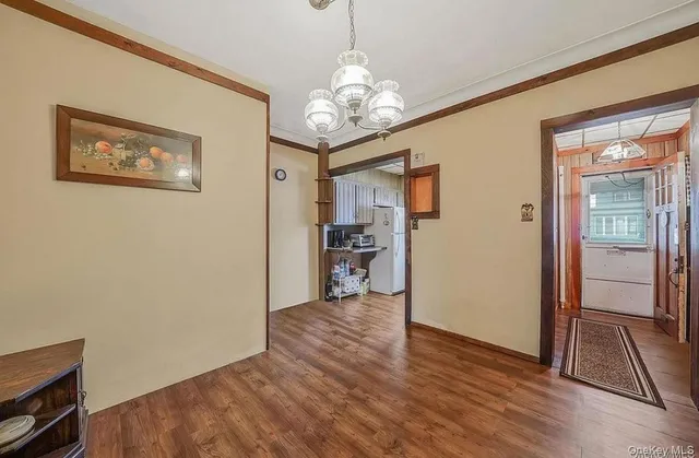 a view of a hallway with wooden floor and a living room
