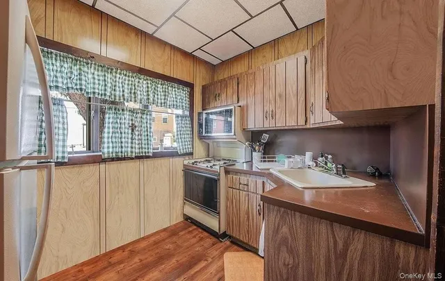 a kitchen with a sink a stove cabinets and a wooden floor