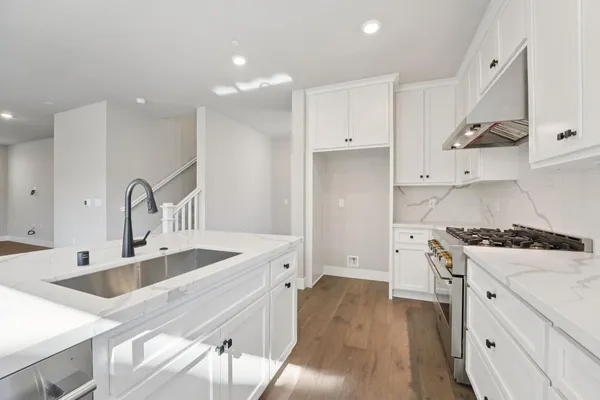 a kitchen with granite countertop a sink stainless steel appliances and cabinets