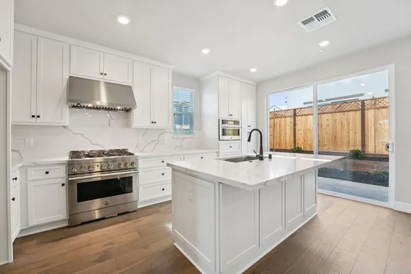a kitchen with stainless steel appliances granite countertop a sink stove and refrigerator
