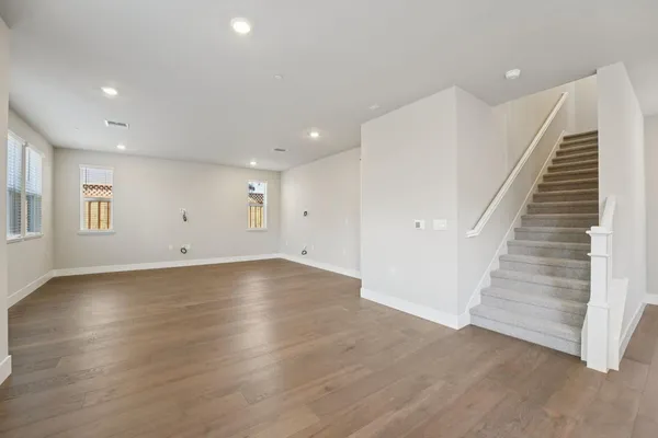 an empty room with wooden floor and white walls