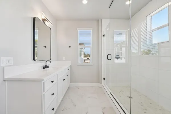 a bathroom with a double vanity sink mirror and shower