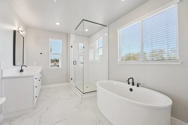 a white bath tub sitting next to a bathroom sink