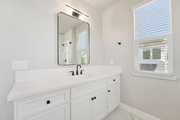 a bathroom with a sink vanity and a mirror