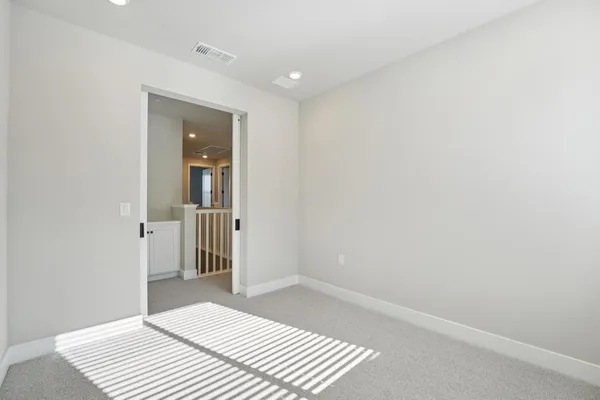 a view of a bedroom with wooden floor and bathroom