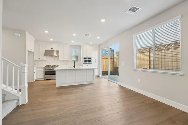 a view of kitchen with kitchen island granite countertop a stove top oven a sink and a refrigerator