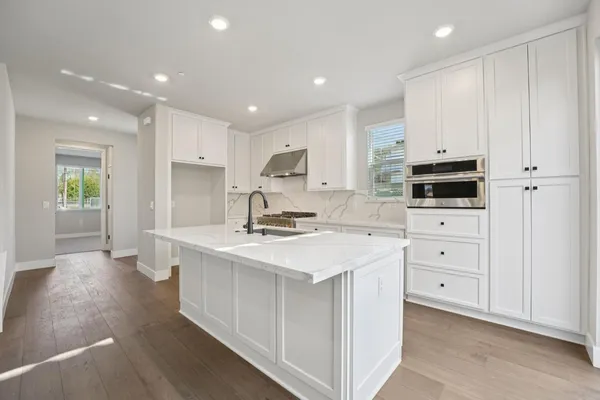 a kitchen with white cabinets appliances and sink