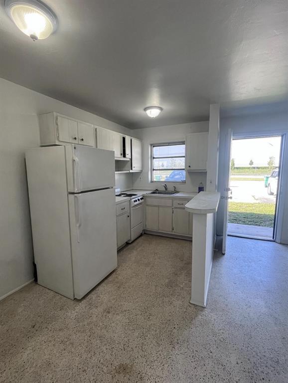 598 Douglas Road, Unit 3 Opa-Locka, FL 33054 - Photo 3 of 5 a kitchen with refrigerator and cabinets