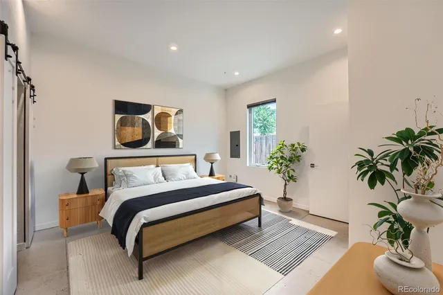 a bedroom with a bed and a potted plant