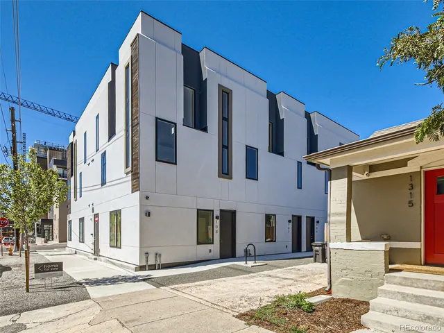 an aerial view of residential houses with outdoor space and trees