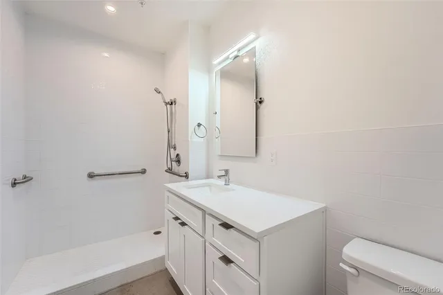 a bathroom with a sink a toilet and shower