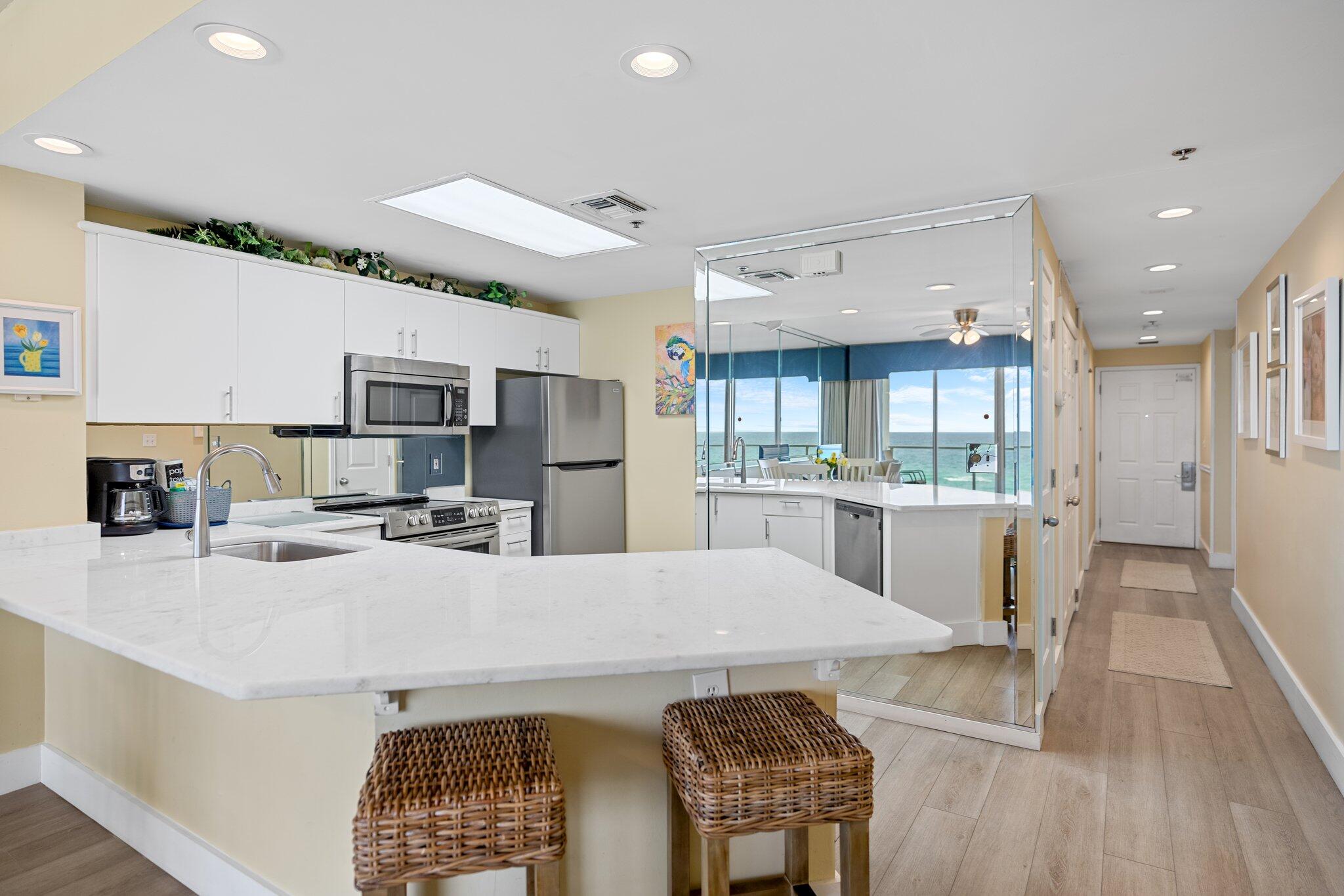 1080 Highway 98, Unit 403 Destin, FL 32541 - Photo 16 of 65 a large white kitchen with lots of counter space a refrigerator and a stove top oven