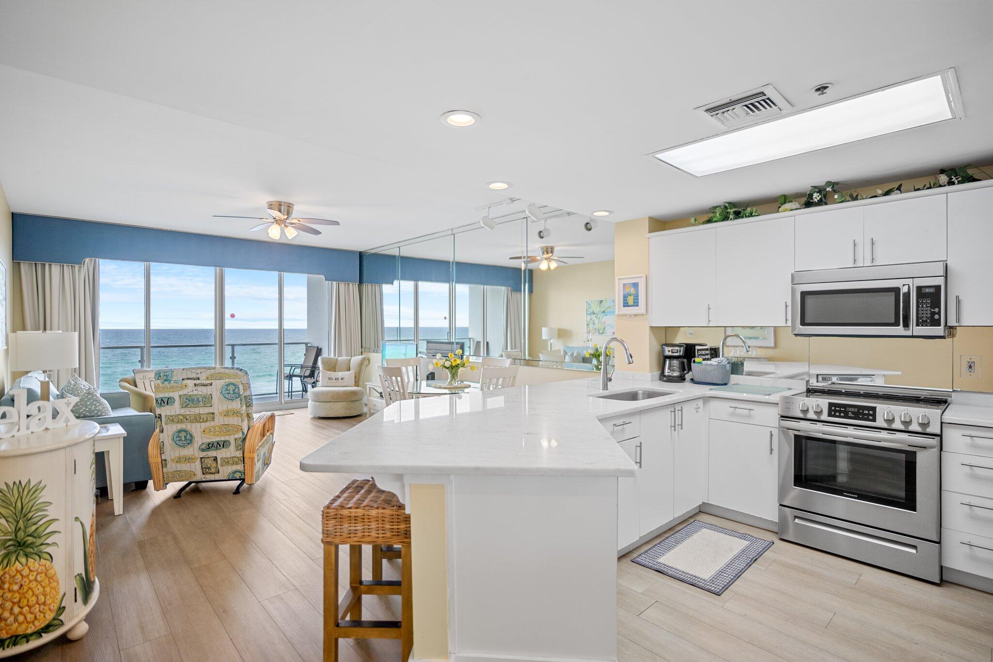 1080 Highway 98, Unit 403 Destin, FL 32541 - Photo 3 of 65 a kitchen with stainless steel appliances granite countertop a stove and white cabinets