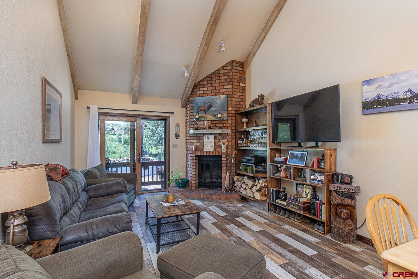 50827 Highway 550, Unit 330 Durango, CO 81301 - Photo 2 of 31 a living room with furniture a fireplace and a flat screen tv