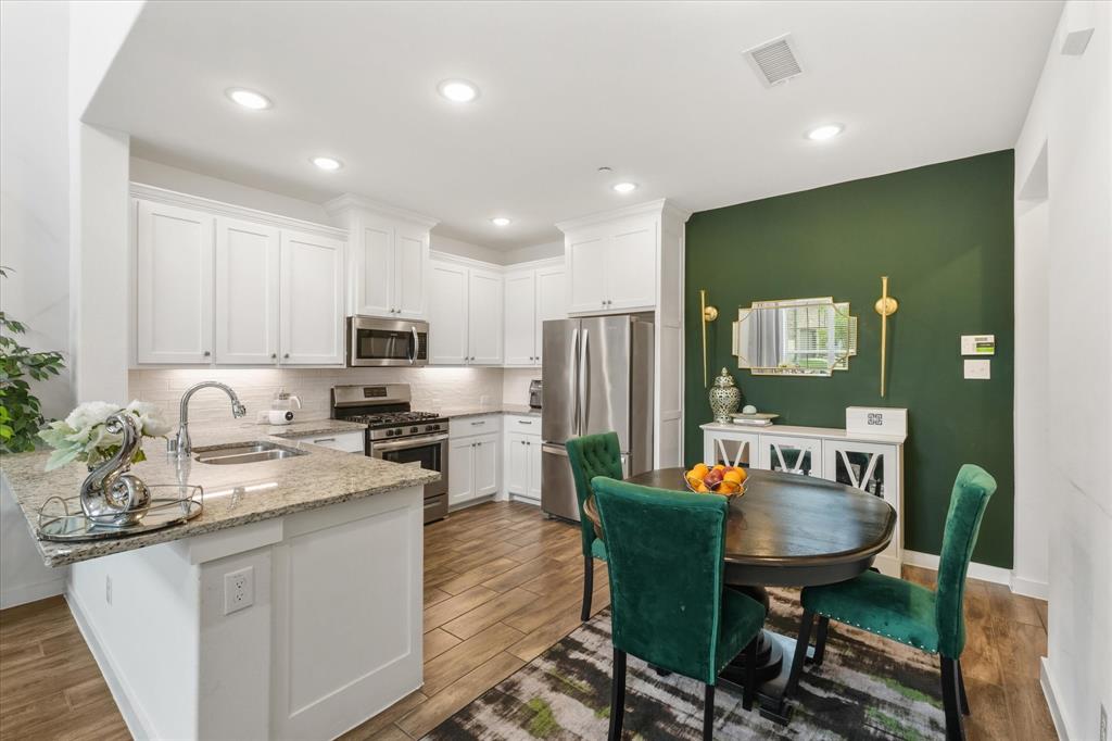 5824 Ridgeline Drive McKinney, TX 75070 - Photo 13 of 31 a kitchen with stainless steel appliances granite countertop sink stove refrigerator dining table and chairs