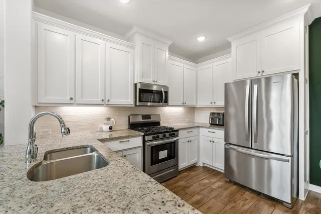 a kitchen with stainless steel appliances granite countertop a refrigerator sink and stove