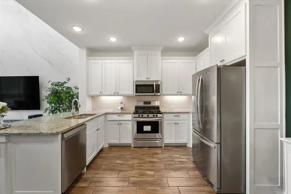 a kitchen with stainless steel appliances granite countertop a refrigerator and a stove top oven