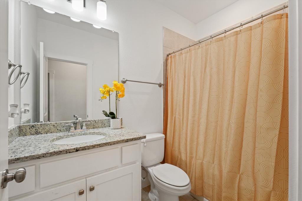 5824 Ridgeline Drive McKinney, TX 75070 - Photo 20 of 31 a bathroom with a granite countertop sink a toilet and a mirror