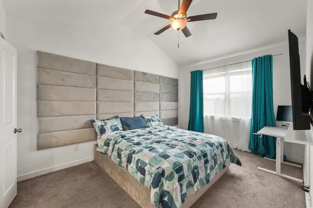 a bedroom with a bed and a flat tv screen on the dresser