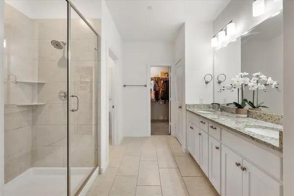 a bathroom with a granite countertop shower sink and mirror