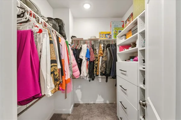 a view of walk in closet with clothes