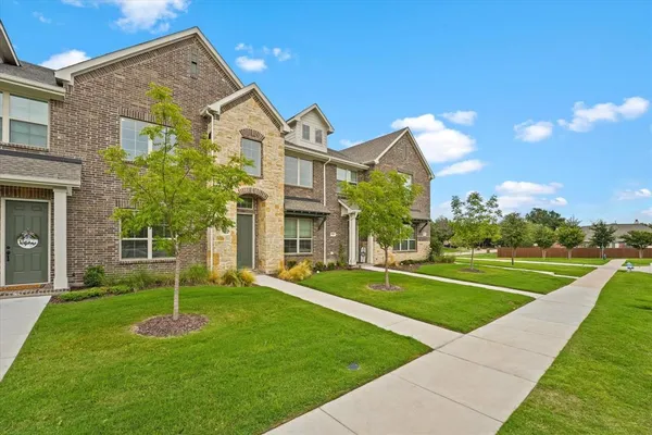 a view of a big house with a big yard and potted plants