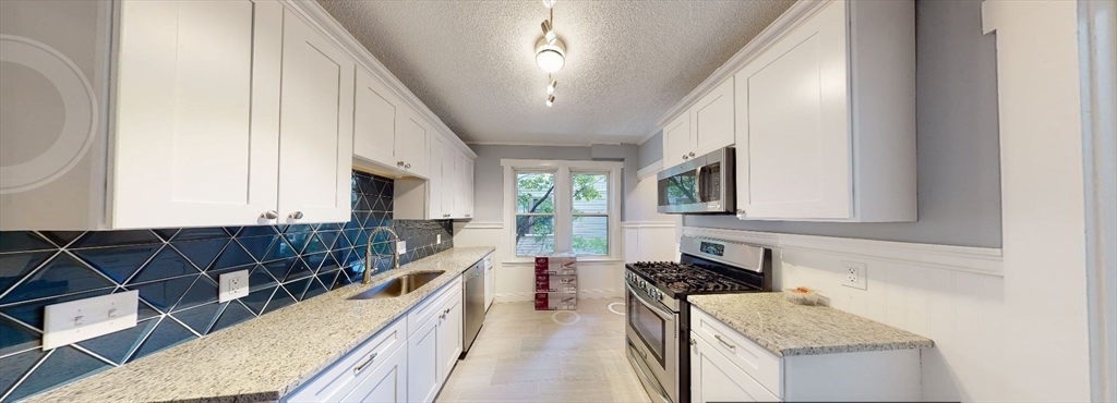 207 Boston Avenue, Unit B Medford, MA 02155 - Photo 1 of 17 a kitchen with stainless steel appliances granite countertop a stove a sink and a microwave