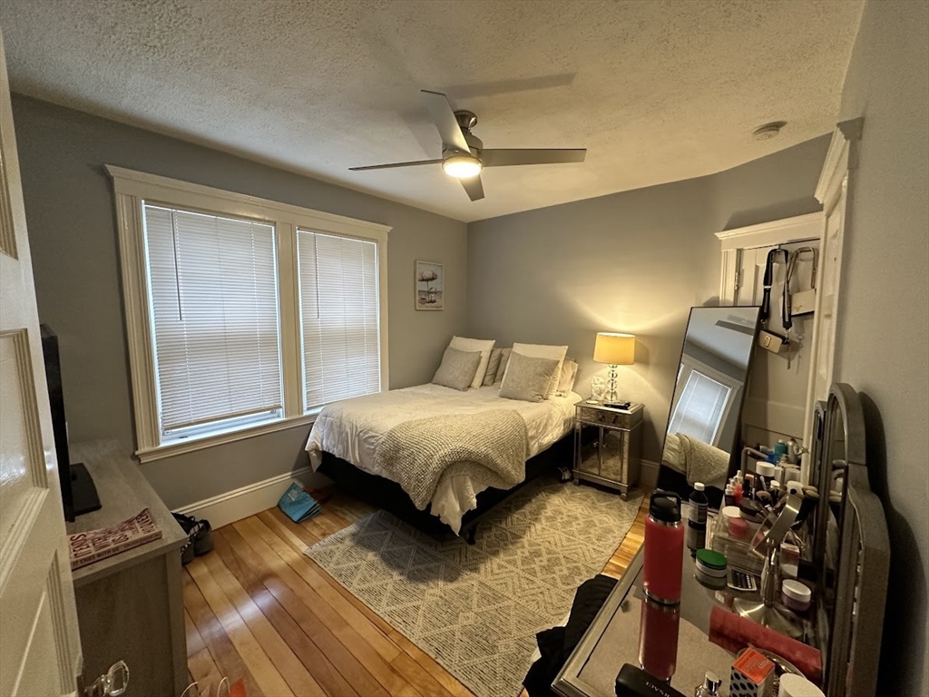 207 Boston Avenue, Unit B Medford, MA 02155 - Photo 15 of 17 a bedroom with a bed and a flat tv screen on a dresser