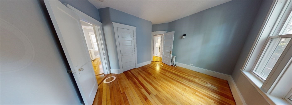 207 Boston Avenue, Unit B Medford, MA 02155 - Photo 6 of 17 a view of an empty room with wooden floor and a window