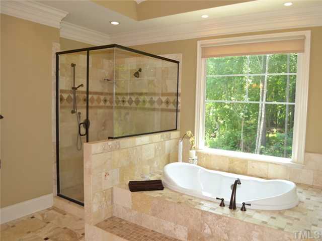 9009 Albatross Court Raleigh, NC 27613 - Photo 20 of 25 a bathroom with a bathtub and a shower