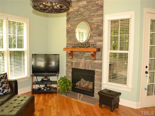 9009 Albatross Court Raleigh, NC 27613 - Photo 6 of 25 a living room with fireplace furniture and a flat screen tv