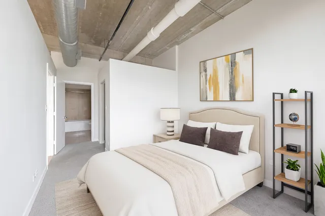 a bedroom with a large bed and a chandelier