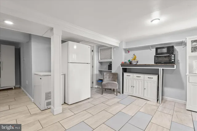 a kitchen with white cabinets and appliances