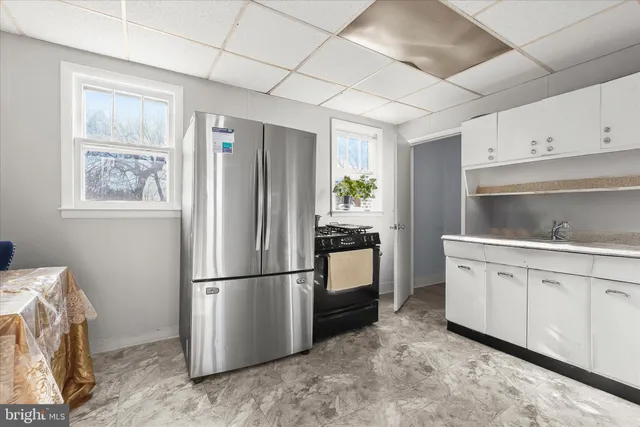 a kitchen with a refrigerator sink and cabinets