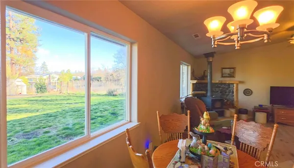 a view of a dining room with furniture a chandelier windows and wooden floor