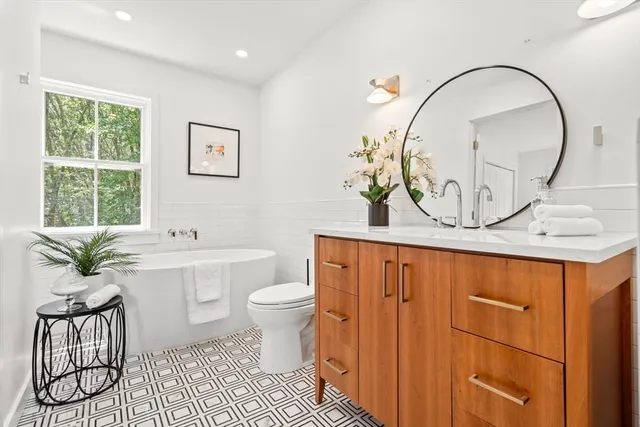 a bathroom with a sink a toilet and a mirror