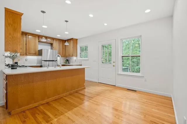a kitchen with stainless steel appliances granite countertop a sink cabinets and wooden floor