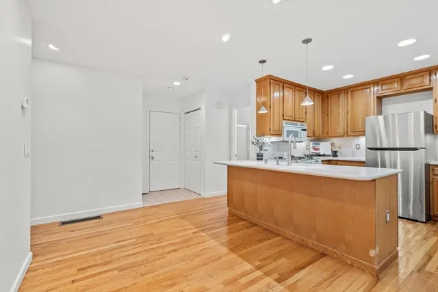 a view of kitchen with granite countertop cabinets and refrigerator