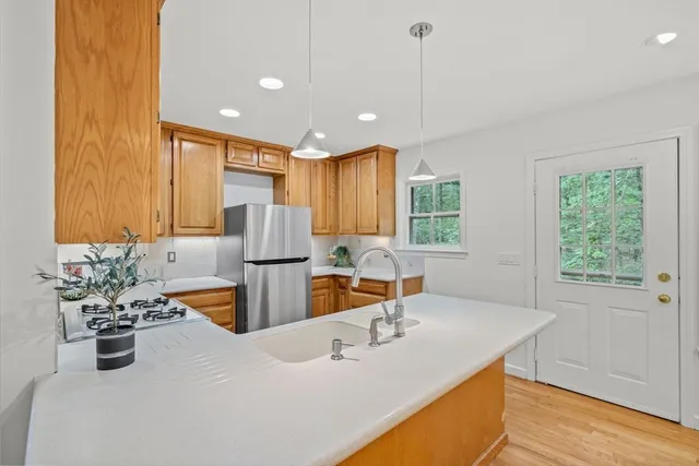 a kitchen with stainless steel appliances granite countertop sink stove and wooden floor