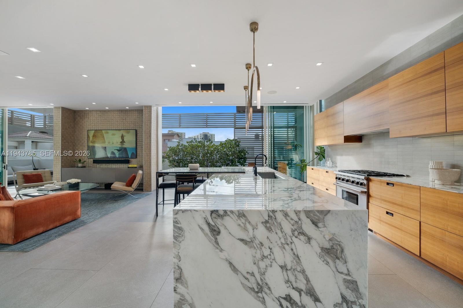 819 2nd Street Miami Beach, FL 33139 - Photo 12 of 32 a kitchen with stainless steel appliances granite countertop a stove a sink a oven and a dining table with white cabinets